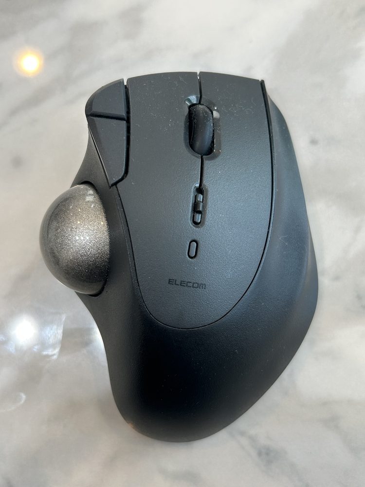MacBookと同時に購入した黒いトラックボール。親指の位置に銀色のボールがある
